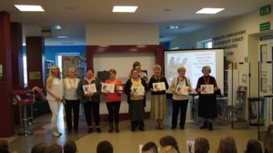 Seniorzy z pamiątkowymi certyfikatami i medalami podczas podsumowania projektu Taneczna gratka dla wnuczka i dziadka